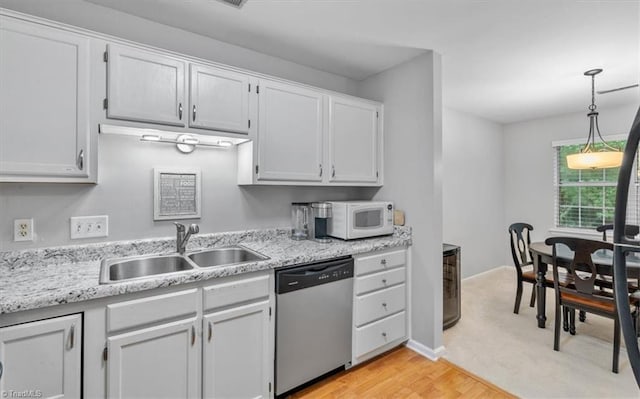 kitchen with hanging light fixtures, dishwasher, sink, and white cabinets