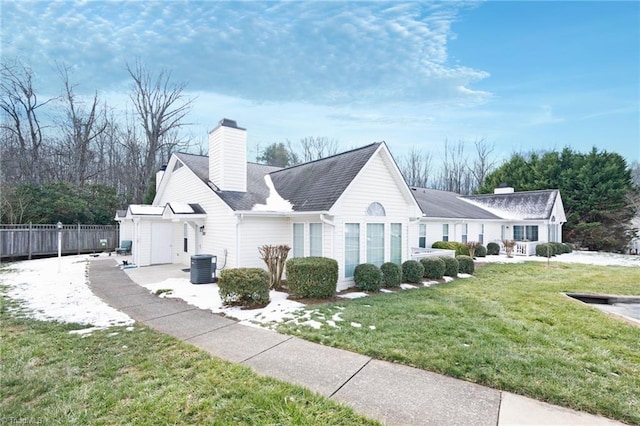 view of front of property with a front yard and central AC unit