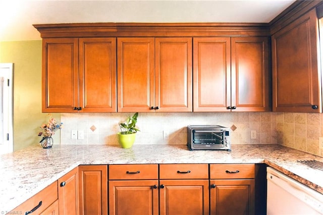 2025 Pope Rd, Winston-Salem, NC 27127 - kitchen featuring white dishwasher, decorative backsplash, brown cabinetry, and light stone counters