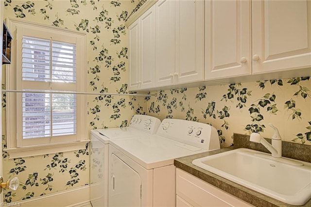 laundry room featuring separate washer and dryer, sink, and cabinets