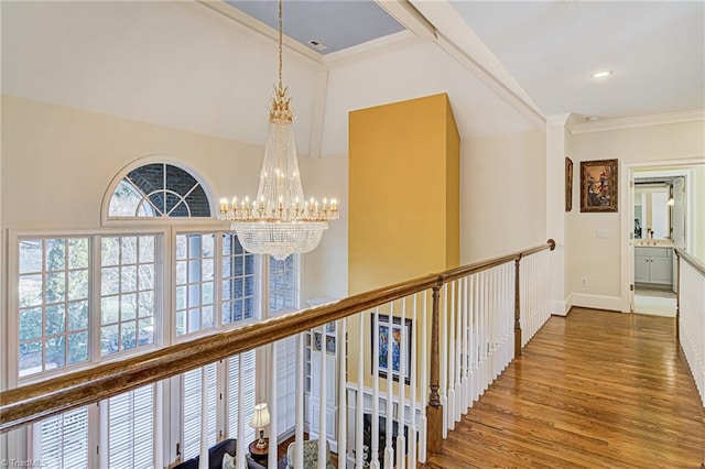 hallway featuring a notable chandelier, wood-type flooring, and lofted ceiling