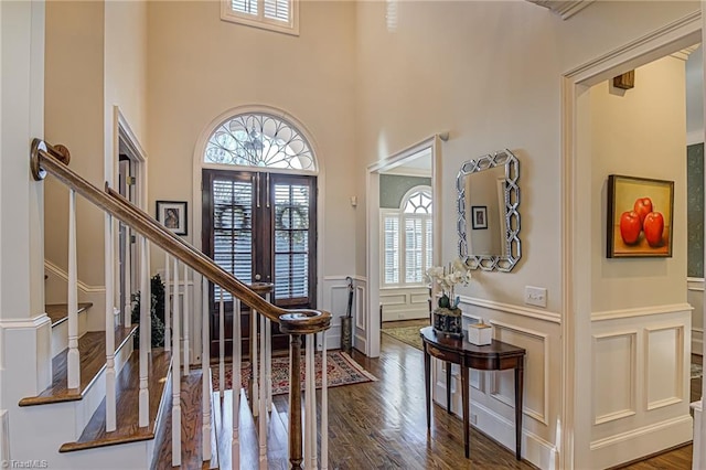 entryway featuring a healthy amount of sunlight, french doors, hardwood / wood-style floors, and a towering ceiling