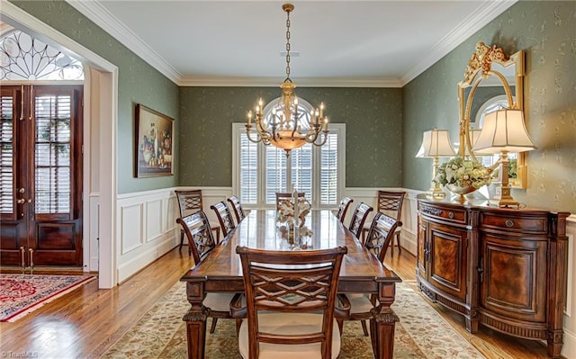 dining room featuring a chandelier, ornamental molding, light hardwood / wood-style flooring, and a healthy amount of sunlight