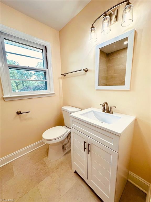 5670 Plantation Dr, Winston-Salem, NC 27105 - bathroom featuring toilet, vanity, and baseboards