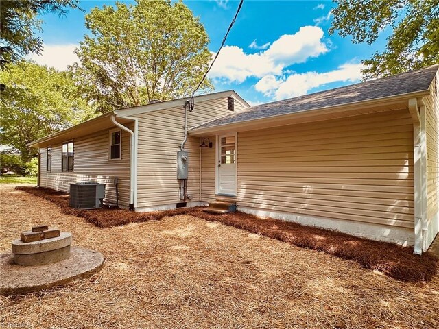 5670 Plantation Dr, Winston-Salem, NC 27105 - back of property with central air condition unit, entry steps, and roof with shingles