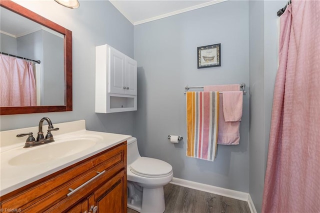 bathroom featuring wood-type flooring, vanity, crown molding, and toilet