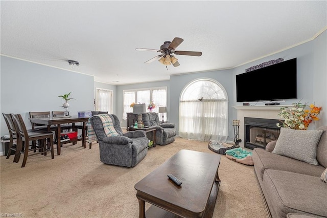 carpeted living room featuring crown molding and ceiling fan