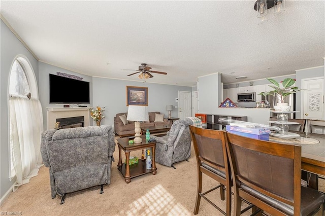 carpeted living room featuring crown molding and ceiling fan