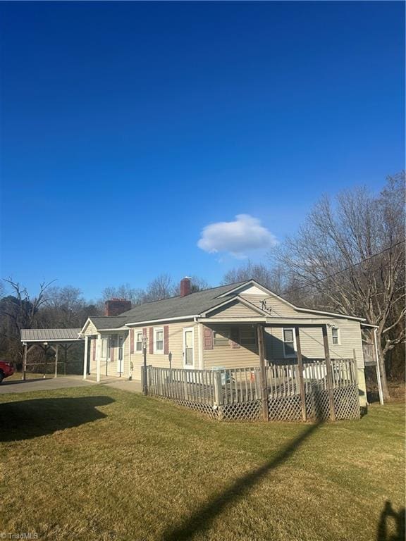 back of house with a lawn and a wooden deck