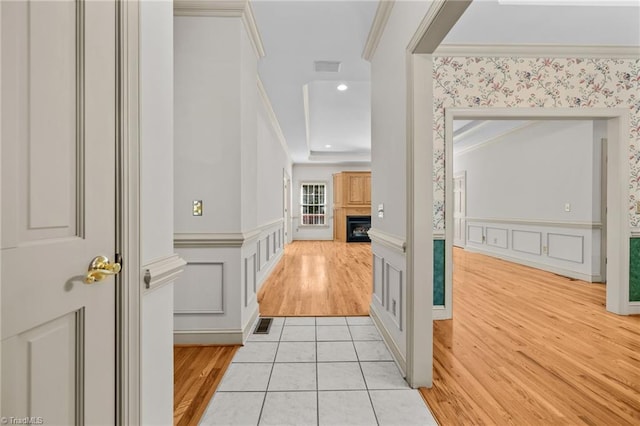 corridor featuring ornamental molding and light wood-type flooring