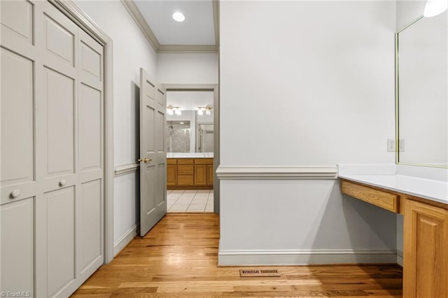 hall with crown molding and light wood-type flooring