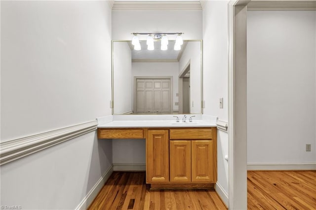 bathroom with vanity, ornamental molding, and wood-type flooring