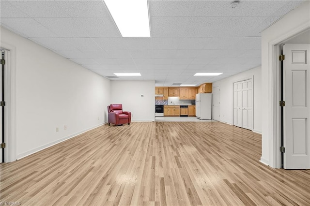 unfurnished living room with a paneled ceiling and light hardwood / wood-style flooring