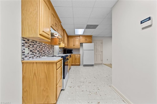 kitchen with white fridge, tasteful backsplash, a drop ceiling, and stove