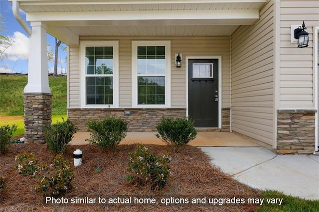 doorway to property with covered porch and stone siding