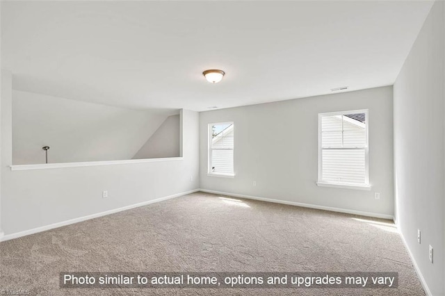 unfurnished room with lofted ceiling, baseboards, and carpet floors