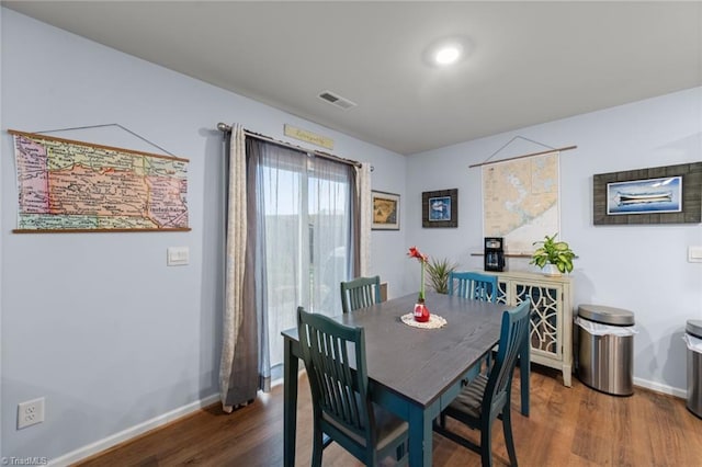 dining room with visible vents, baseboards, and wood finished floors