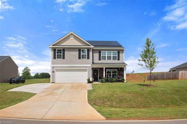 traditional-style home featuring an attached garage, solar panels, fence, concrete driveway, and a front lawn