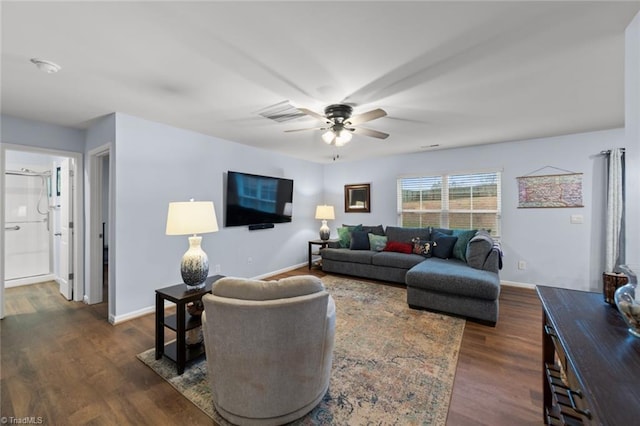 living area featuring dark wood-type flooring, baseboards, and a ceiling fan