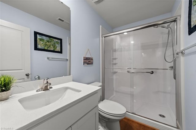 full bathroom featuring a stall shower, visible vents, vanity, and toilet