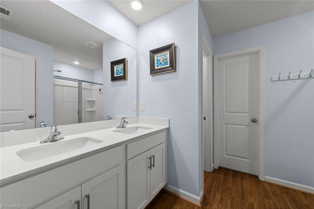 bathroom with a shower stall, visible vents, a sink, and wood finished floors