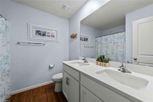 full bath with visible vents, a sink, toilet, and wood finished floors