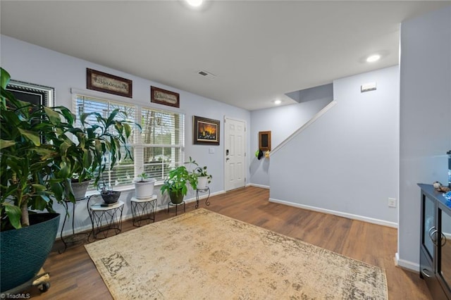 entryway featuring stairway, wood finished floors, visible vents, and baseboards