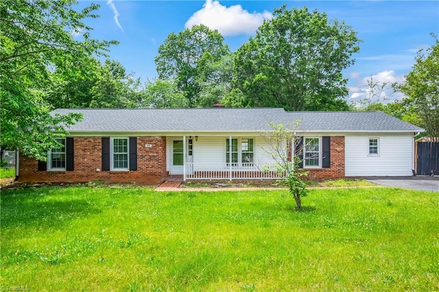 ranch-style home with covered porch, a front lawn, and brick siding