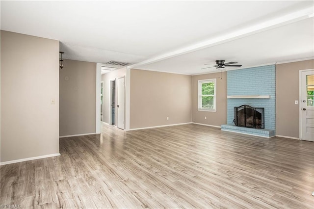 unfurnished living room with ceiling fan, visible vents, a fireplace, baseboards, and light wood finished floors