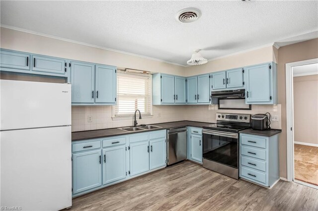 kitchen with a sink, blue cabinets, dark countertops, and stainless steel appliances