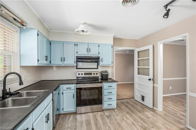 kitchen featuring a sink, appliances with stainless steel finishes, blue cabinets, and dark countertops