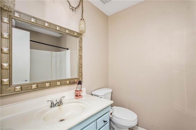 bathroom with walk in shower, toilet, visible vents, and vanity
