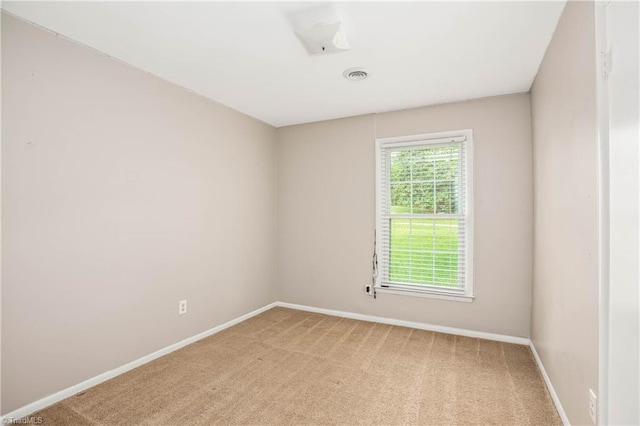 carpeted spare room featuring baseboards and visible vents