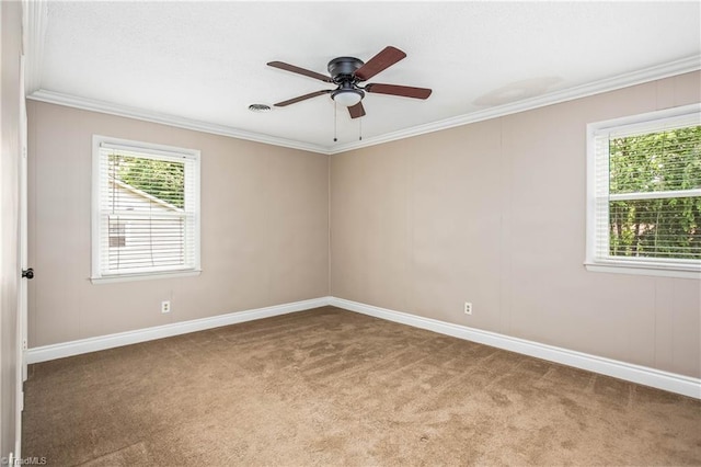 carpeted empty room with ceiling fan, ornamental molding, and baseboards