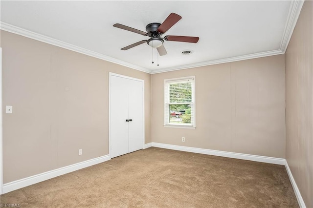 empty room with light colored carpet, baseboards, visible vents, and ornamental molding