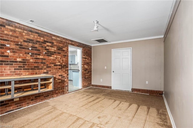 carpeted spare room with baseboards, ornamental molding, and a ceiling fan