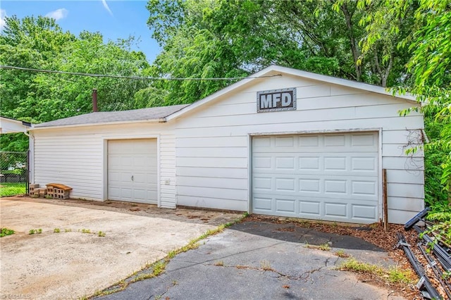 detached garage featuring fence
