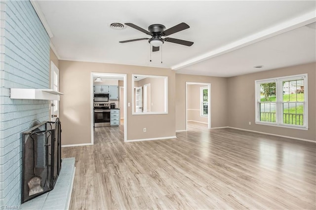 unfurnished living room with a brick fireplace, a ceiling fan, baseboards, and light wood-style flooring