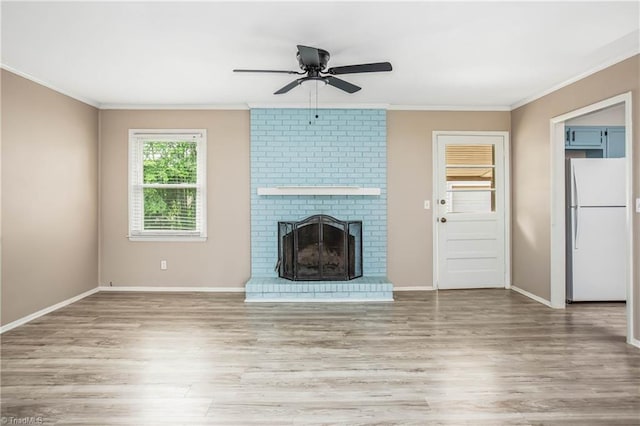 unfurnished living room with baseboards, ceiling fan, ornamental molding, and wood finished floors