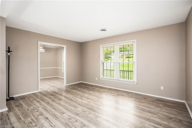 empty room with baseboards, visible vents, and light wood-style floors
