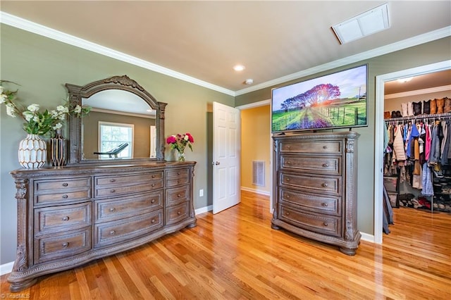 3289 Tobaccoville Rd, Tobaccoville, NC 27050 - bedroom featuring a walk in closet, light wood finished floors, visible vents, and ornamental molding