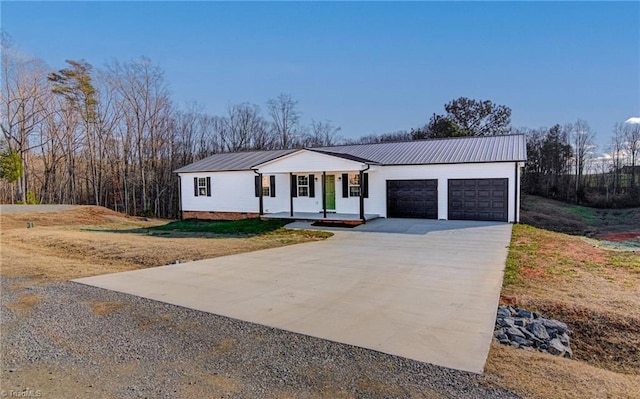 view of front of property featuring a garage, covered porch, and a front lawn