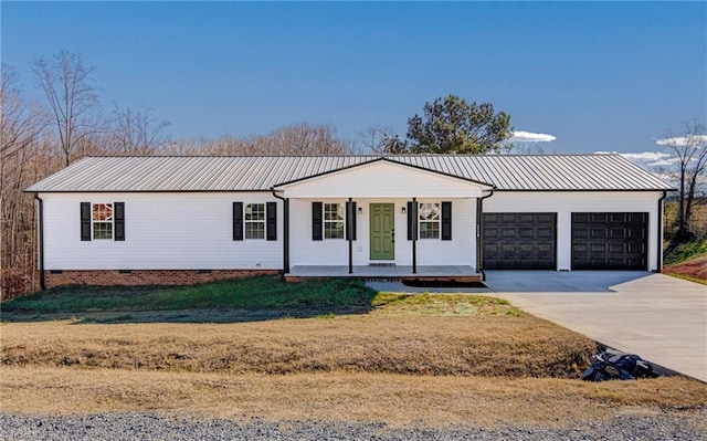 view of front of home featuring covered porch, a garage, and a front lawn