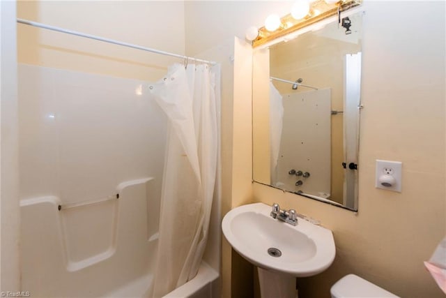 full bathroom with shower / tub combo with curtain, toilet, and sink