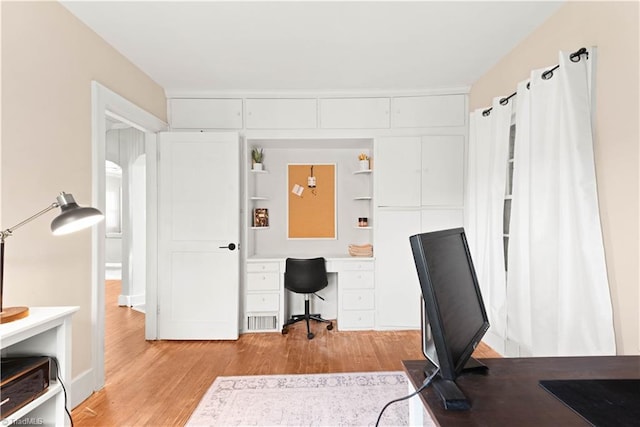 home office with light hardwood / wood-style floors