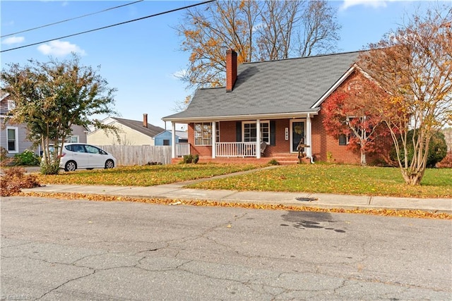 bungalow with covered porch and a front yard