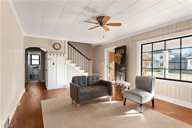 living area with hardwood / wood-style floors, ceiling fan, and crown molding