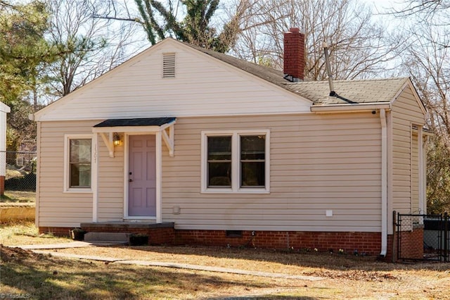 view of front facade featuring roof with shingles, crawl space, a chimney, and fence