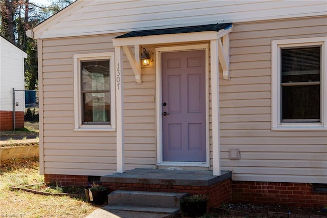 doorway to property with crawl space and fence