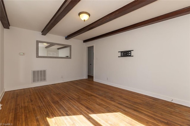 empty room featuring beam ceiling, wood finished floors, visible vents, and baseboards